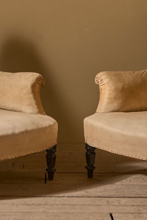 fig 1. A pair of French Napoleon III armchairs with square upholstered backs, padded arms, neutral beige fabric, and turned dark wood legs.