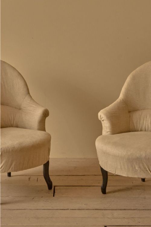 fig 1. A pair of antique French Napoleon III tub chairs upholstered in neutral calico with dark turned wooden legs.