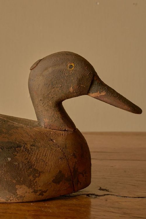 fig 2. An early 20th-century hand-carved wooden decoy duck featuring weathered brown and green painted finishes.