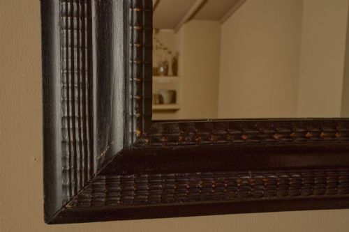 fig 2. A rectangular 19th-century Italian wall mirror featuring a dark ebonised wooden frame with textured carved moulding.