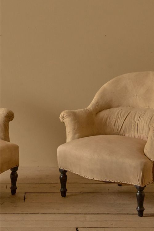 fig 1. A pair of antique French Napoleon III tub armchairs upholstered in neutral beige fabric with turned ebonised front legs.