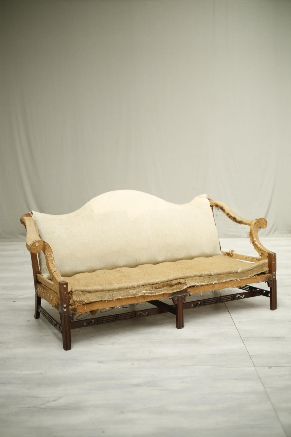 American c.1920's camel backed sofa with fret work stretcher