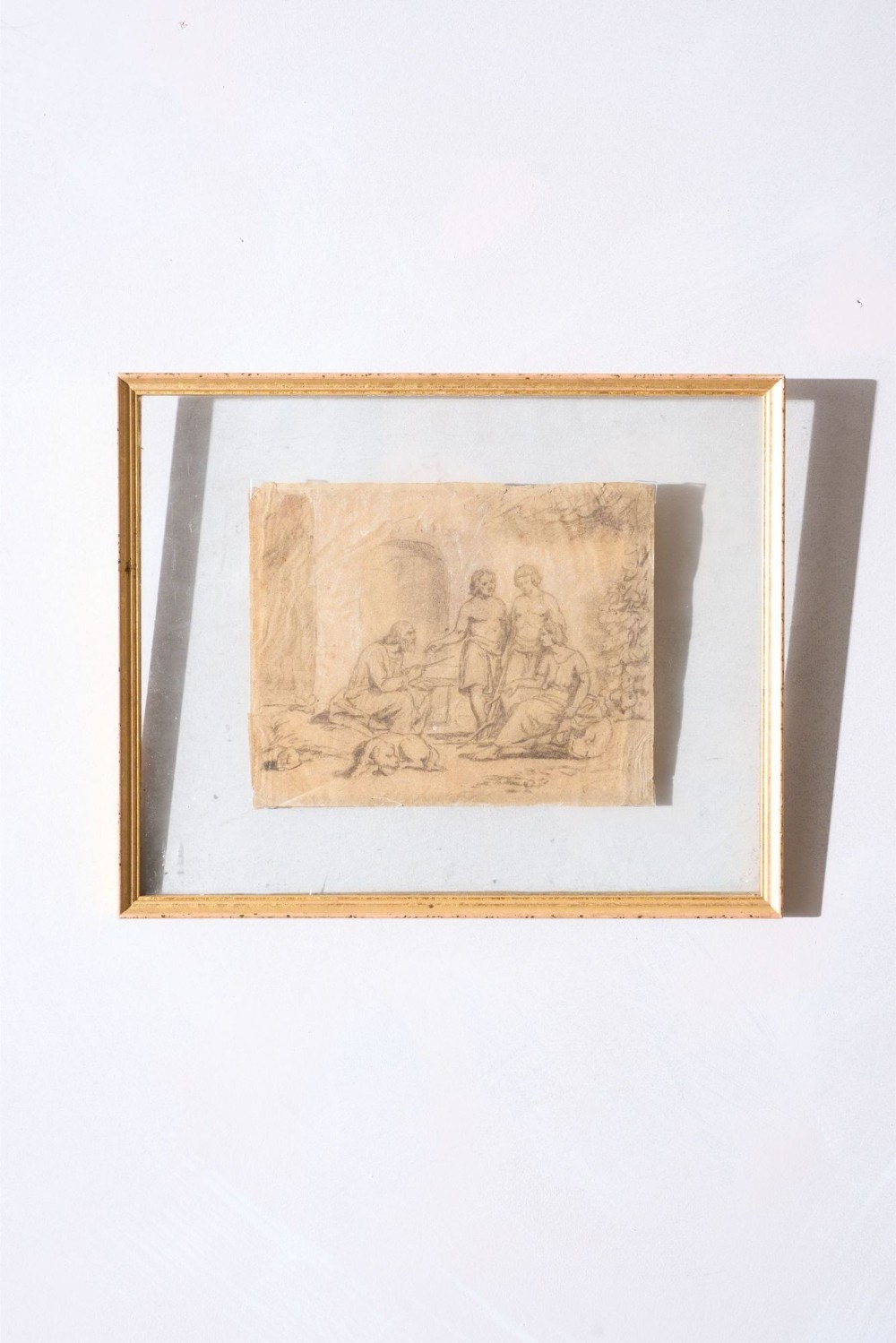 An 18th-century pencil sketch on aged paper depicting an old man seated with three figures, float-mounted inside a slender gilt wood frame.