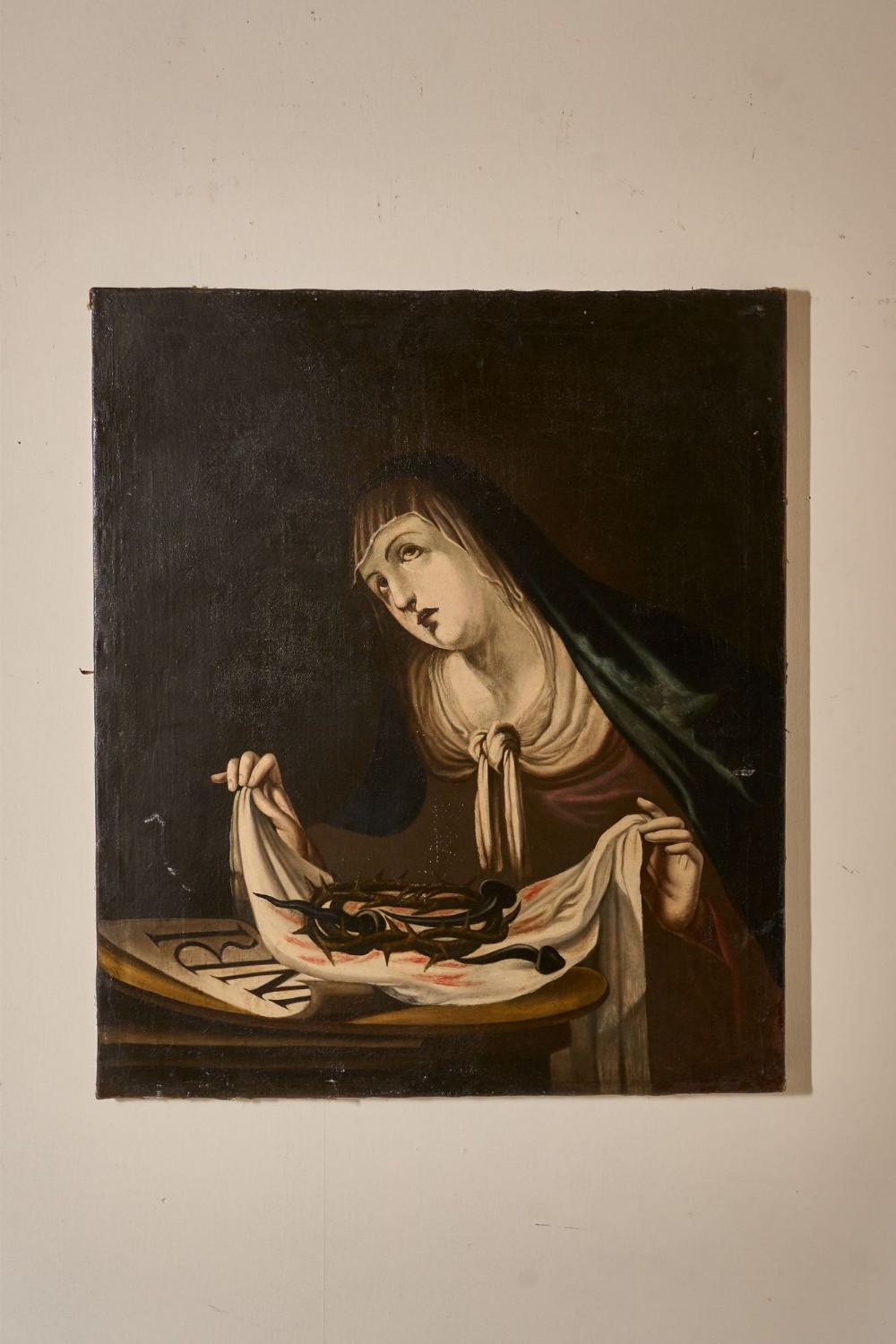 An 18th-century Spanish oil painting on canvas depicting the Virgin Mary gazing upwards while holding the Crown of Thorns and nails.