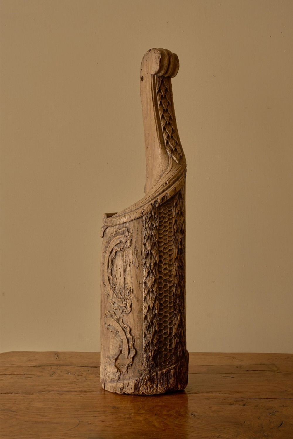 A vertical 18th-century hand-carved oak newel post element featuring textured scale carvings, scroll details, and a natural weathered timber finish.