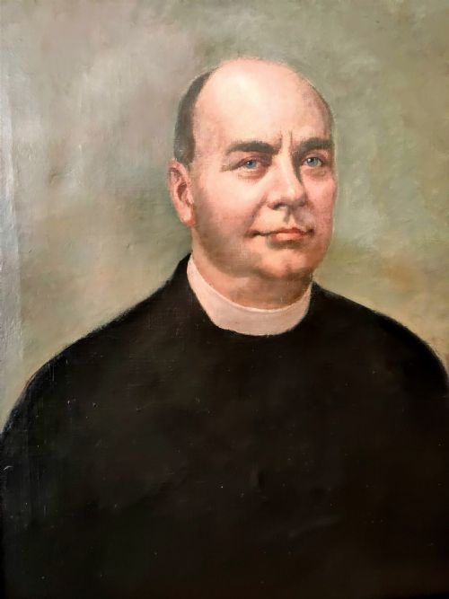 fig 1. An oil on canvas portrait from the 1920s depicting a clergyman in a black coat and collar inside a gold gilt frame.