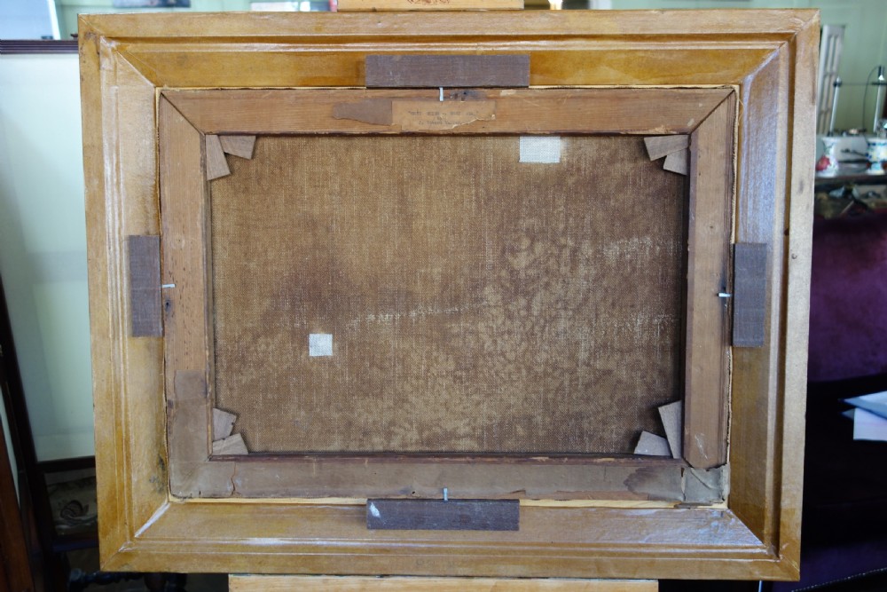 An early 20th-century impressionist oil painting depicting waves crashing against rocky coastal cliffs under cloudy grey skies, enclosed in a dark molded wooden frame with a gilded inner border. View III
