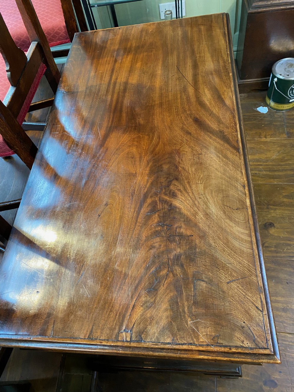An eighteenth century Georgian mahogany kneehole desk featuring multiple drawers with brass handles, a central recessed cupboard, and bracket feet. View II