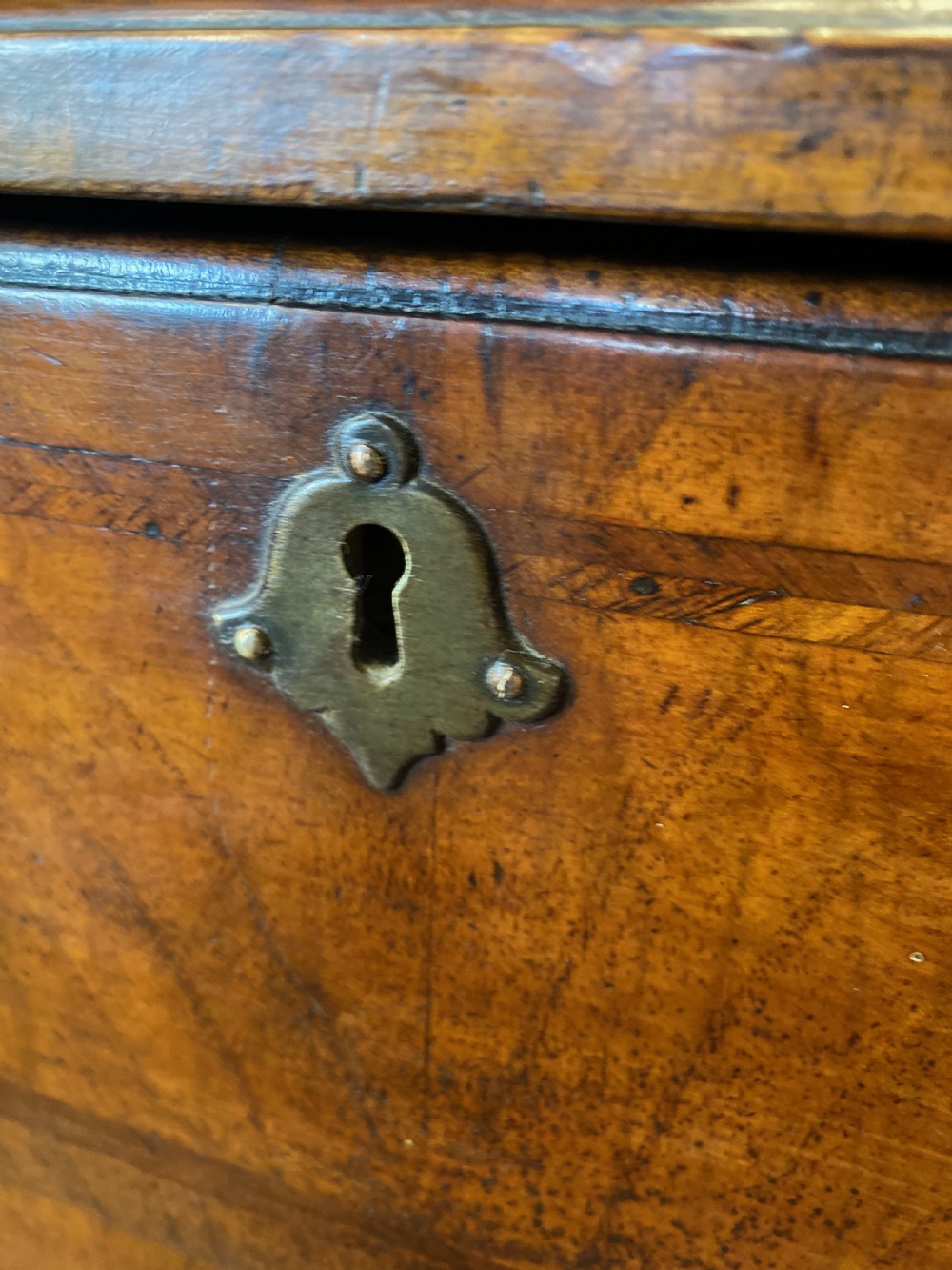 Mid 18th-century walnut kneehole secretaire desk featuring crossbanded drawer fronts, brass drop handles, a central recessed cupboard, and bracket feet. View II