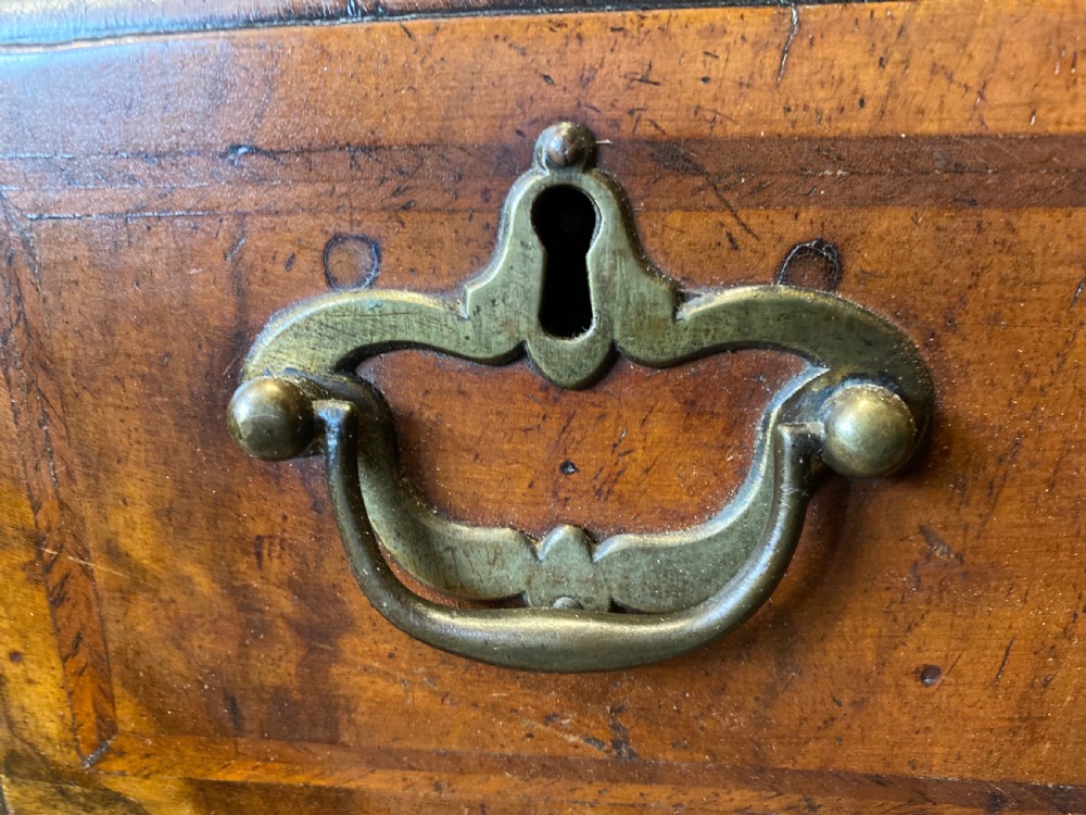 Mid 18th-century walnut kneehole secretaire desk featuring crossbanded drawer fronts, brass drop handles, a central recessed cupboard, and bracket feet. View IX