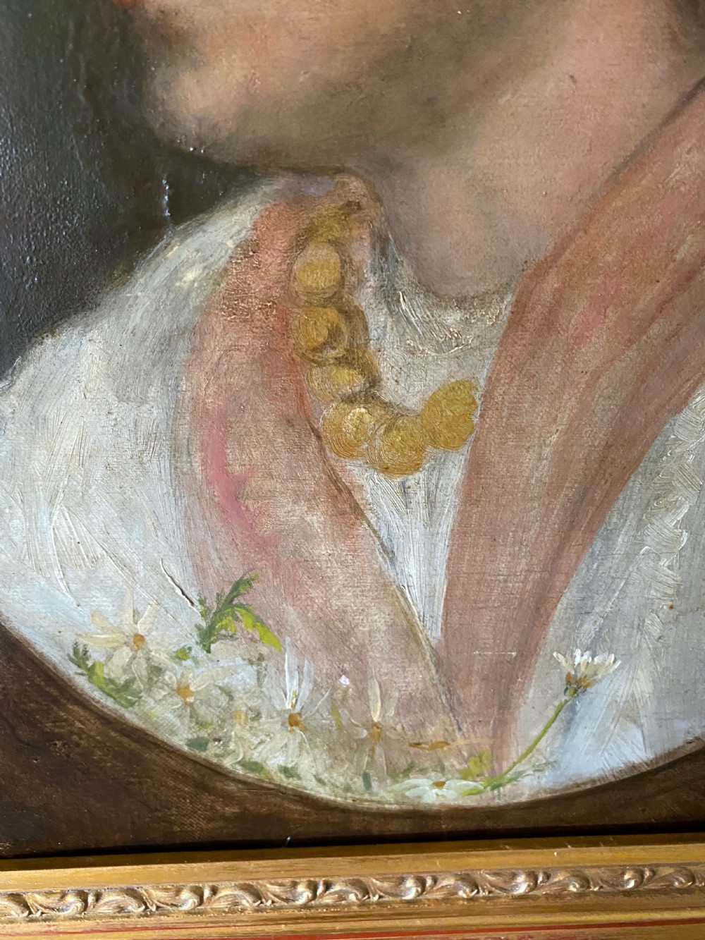 A 19th-century oil portrait depicting the side profile of a young girl wearing a white headscarf, pink shawl, and gold necklace, set within a moulded gilt frame. View II