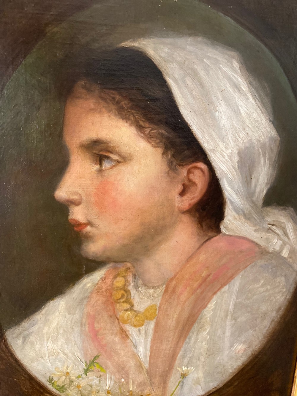 A 19th-century oil portrait depicting the side profile of a young girl wearing a white headscarf, pink shawl, and gold necklace, set within a moulded gilt frame. View IV