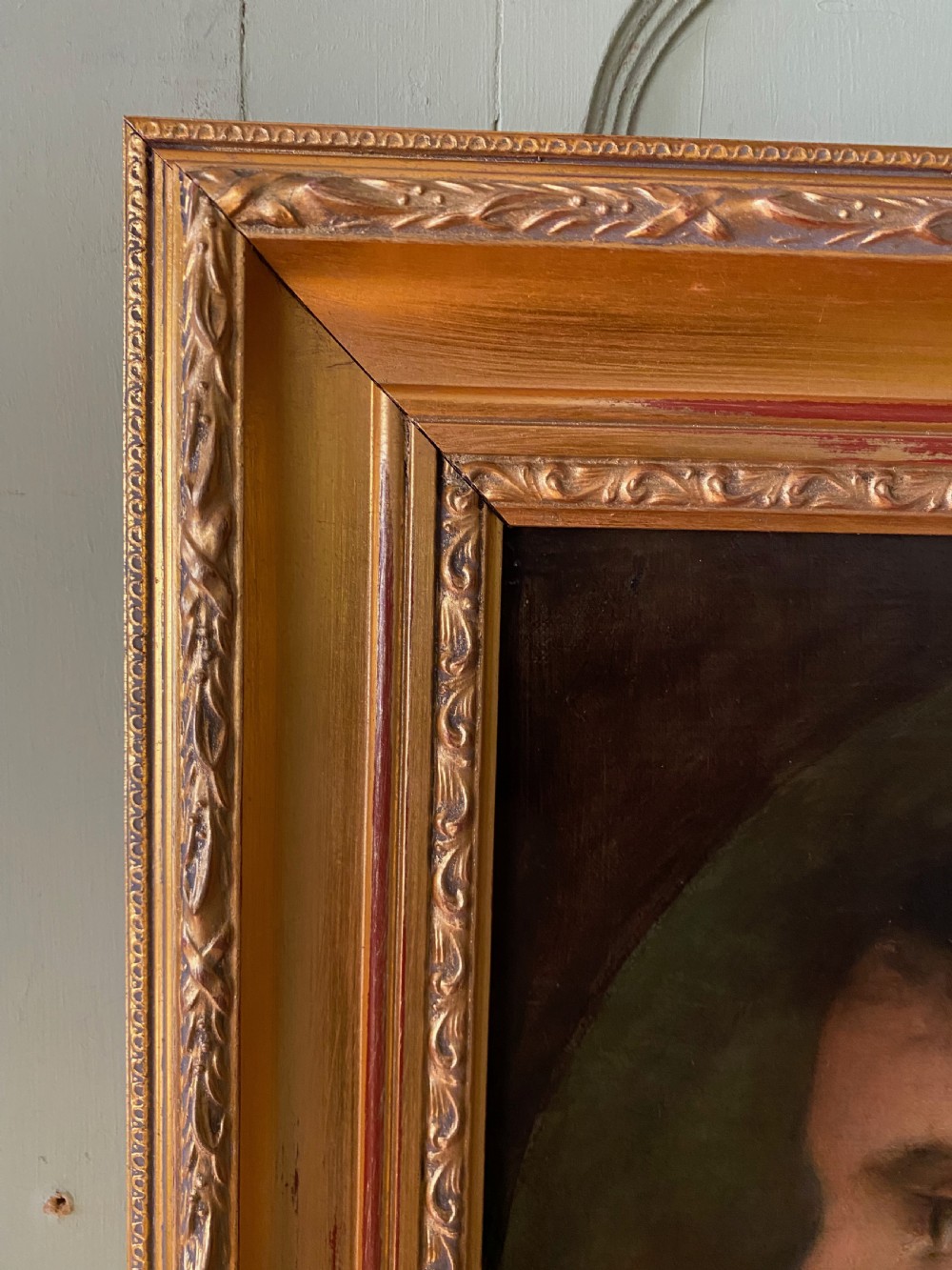 A 19th-century oil portrait depicting the side profile of a young girl wearing a white headscarf, pink shawl, and gold necklace, set within a moulded gilt frame. View VI