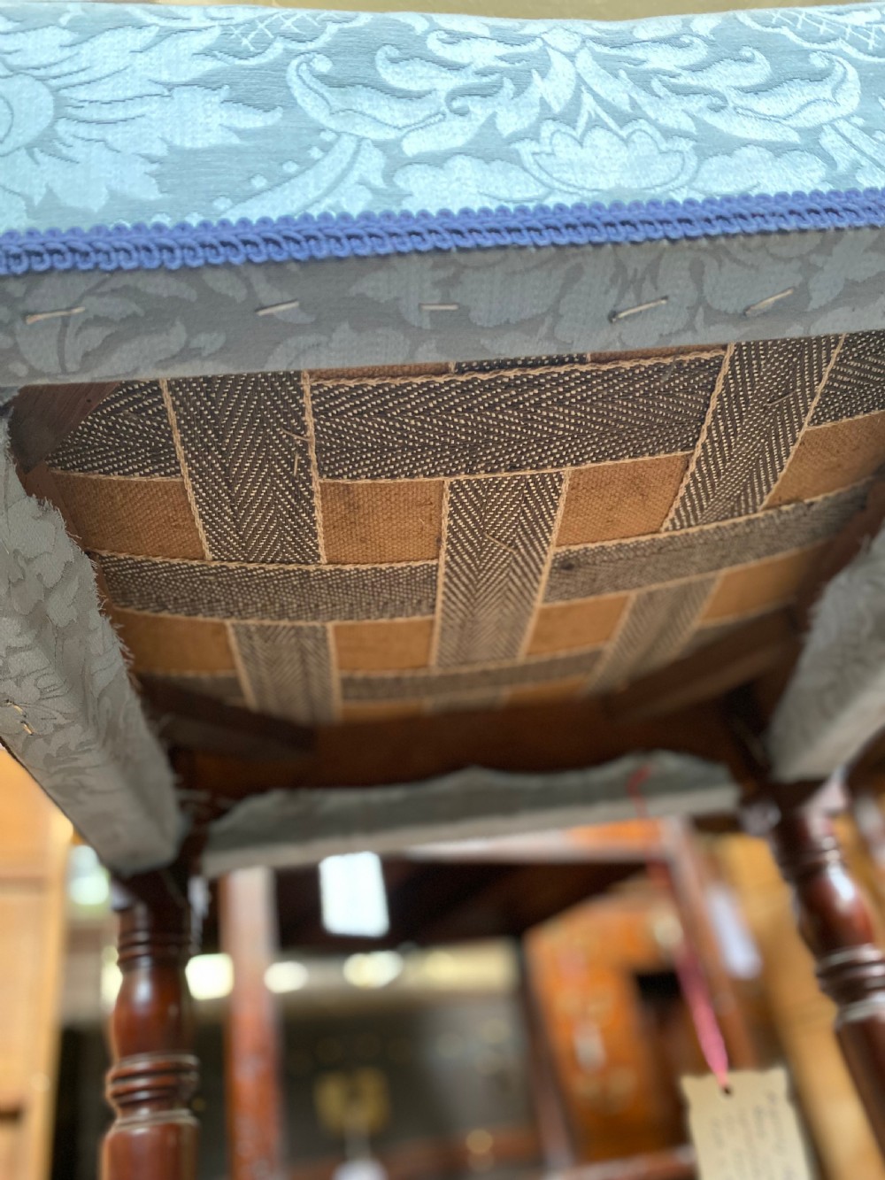 A square Regency stool upholstered in cream patterned fabric with dark turned mahogany legs. View IV