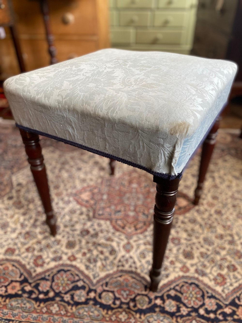 A square Regency stool upholstered in cream patterned fabric with dark turned mahogany legs. View VI
