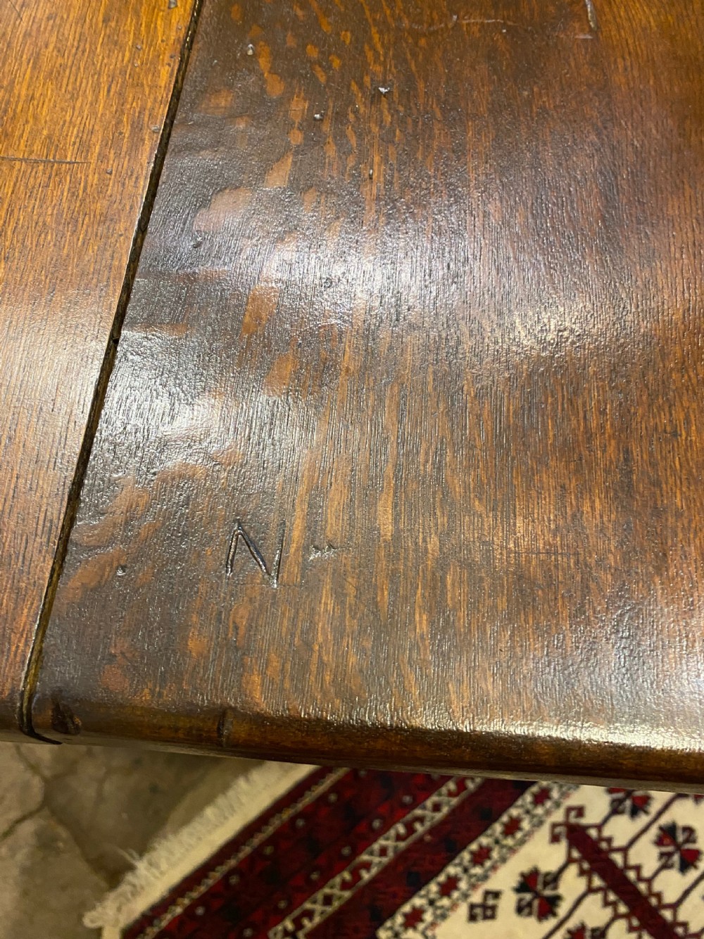 An early nineteenth-century solid oak refectory table featuring a two-plank top supported by shaped trestle end supports and a central stretcher. View III