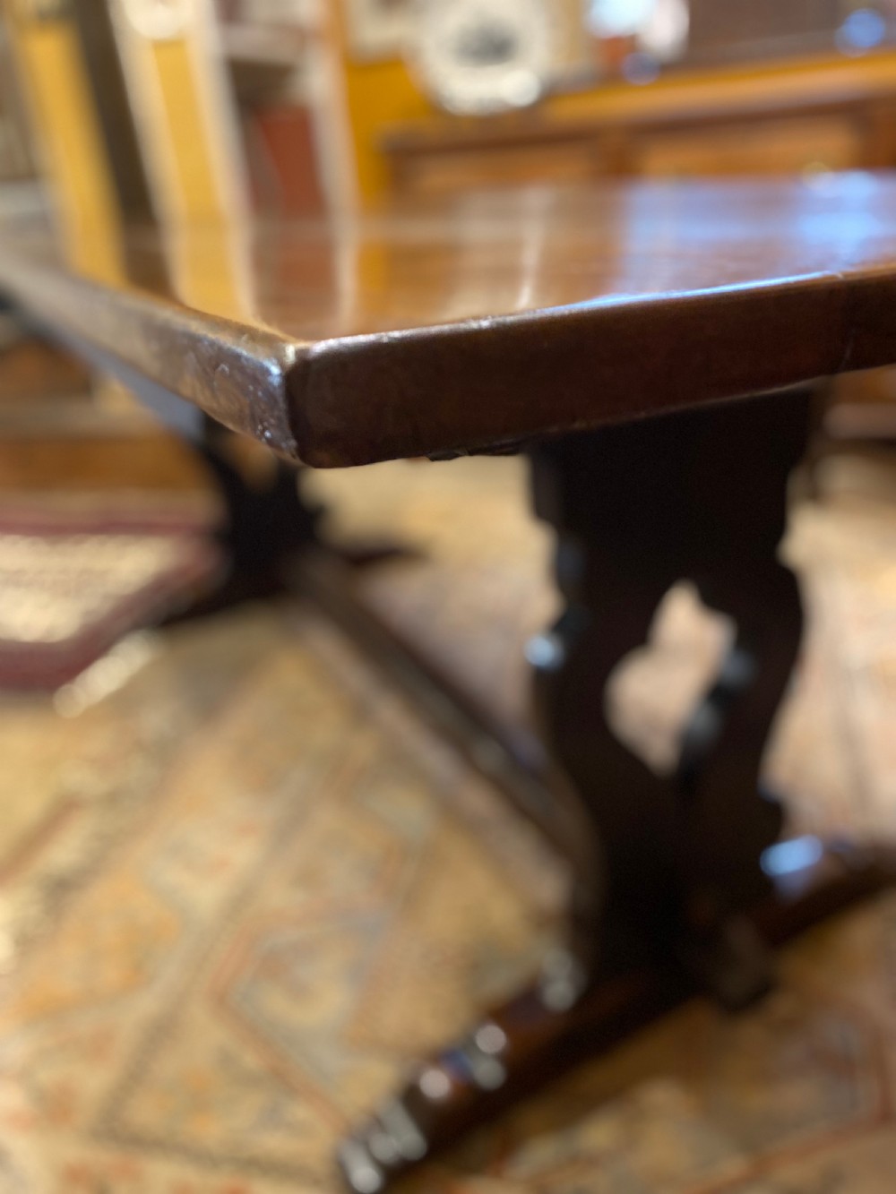 An early nineteenth-century solid oak refectory table featuring a two-plank top supported by shaped trestle end supports and a central stretcher. View V