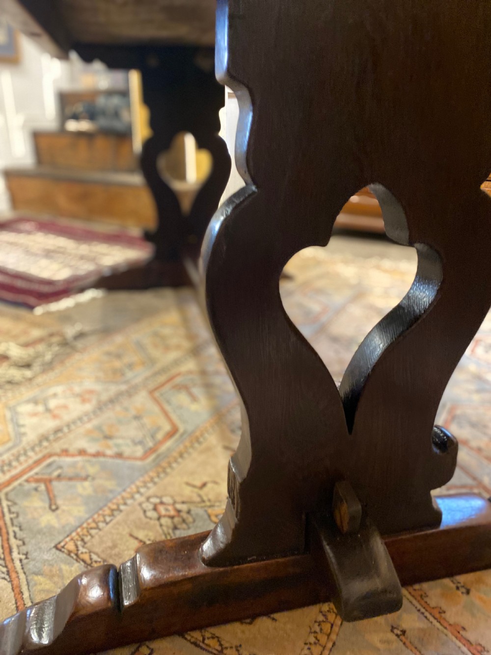 An early nineteenth-century solid oak refectory table featuring a two-plank top supported by shaped trestle end supports and a central stretcher. View VI