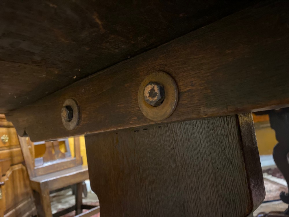 An early nineteenth-century solid oak refectory table featuring a two-plank top supported by shaped trestle end supports and a central stretcher. View VII