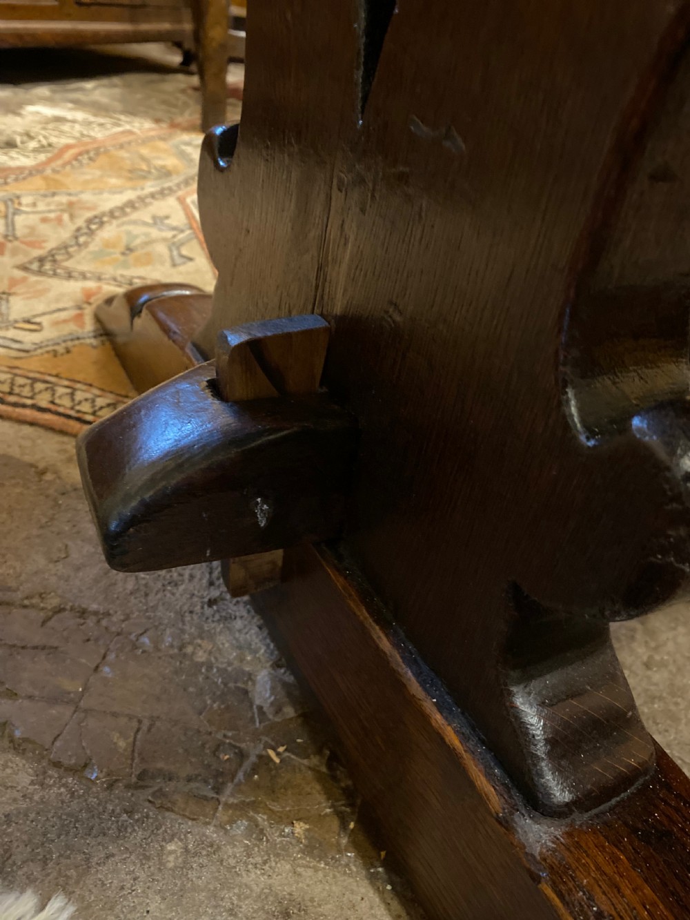 An early nineteenth-century solid oak refectory table featuring a two-plank top supported by shaped trestle end supports and a central stretcher. View VIII