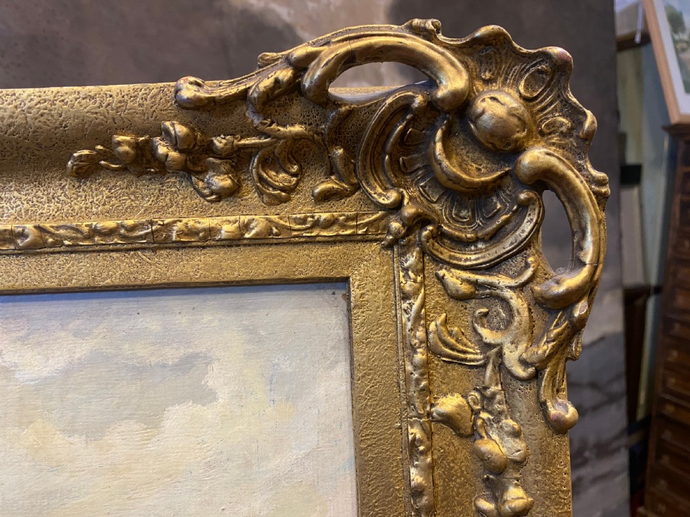 An antique oil painting depicting figures in period costume gathered in a woodland landscape, set within an ornate gilded frame. View VI