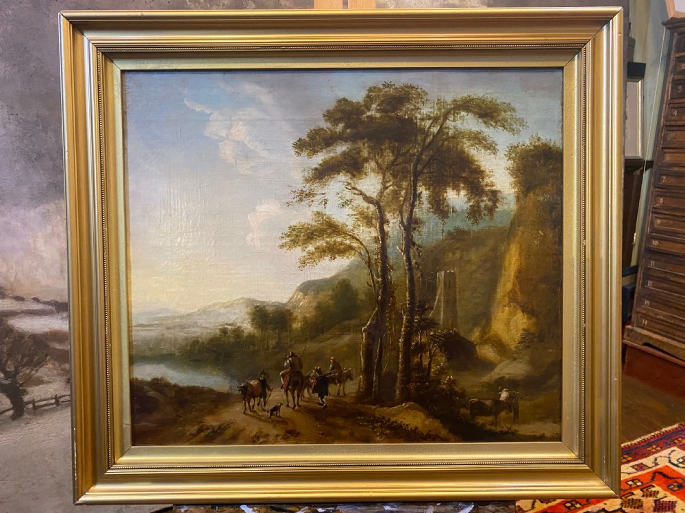 An eighteenth-century Dutch style oil painting on canvas depicting travellers and livestock on a path in a wooded landscape, housed in a golden moulded frame.