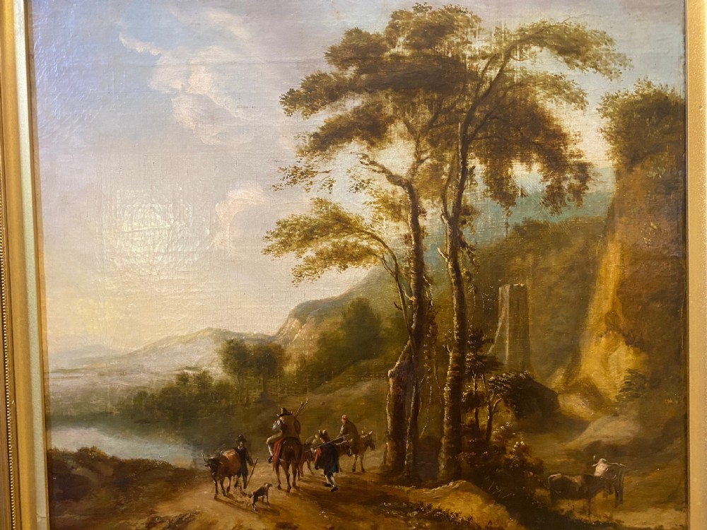 An eighteenth-century Dutch style oil painting on canvas depicting travellers and livestock on a path in a wooded landscape, housed in a golden moulded frame. View II