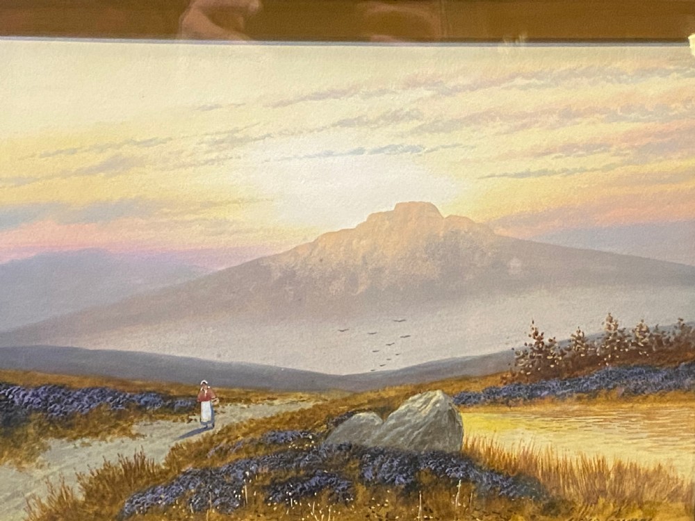 A framed watercolour landscape painting showing a figure walking across moorland toward a mountain under a glowing sky, encased in a dark frame with a gilt inner slip. View II