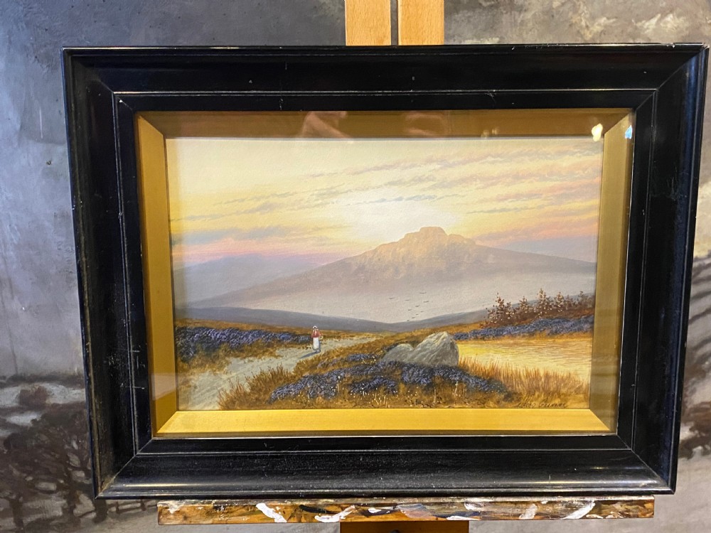 A framed Victorian watercolour painting by Alfred Graham depicting a figure walking on a path through a moorland landscape towards a distant hill under a luminous sky.