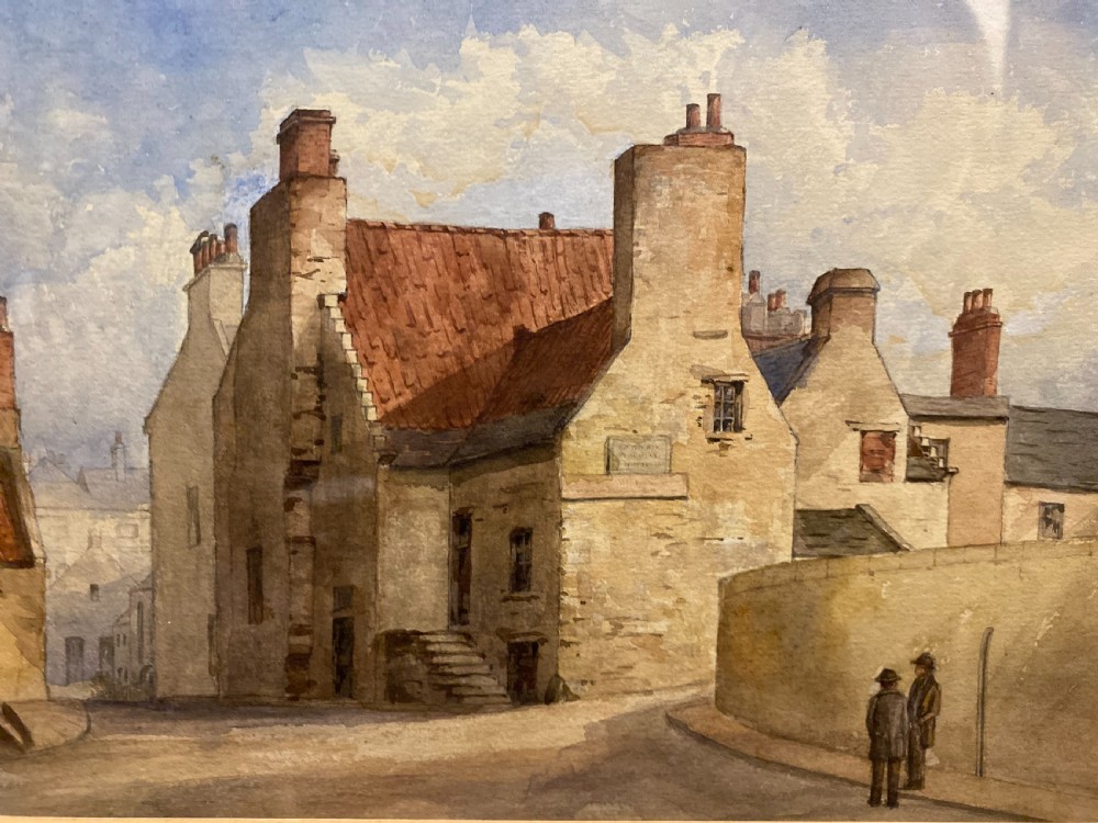 A framed watercolour painting depicting stone village houses with red-tiled roofs along a quiet street under a cloud-filled sky. View IV