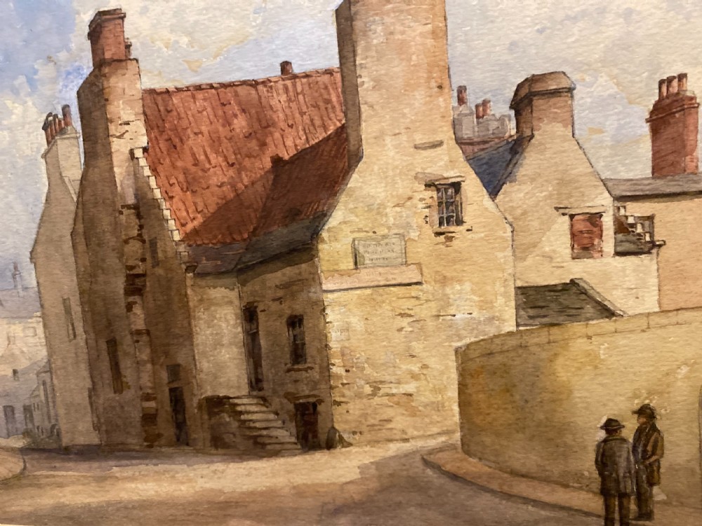 A framed watercolour painting depicting stone village houses with red-tiled roofs along a quiet street under a cloud-filled sky. View V
