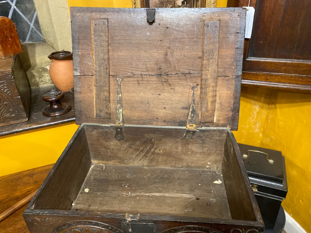 A dark oak wooden bible box featuring a flat hinged top, an iron lock plate, and hand-carved demi-lune fan motifs across the front panel. View IV