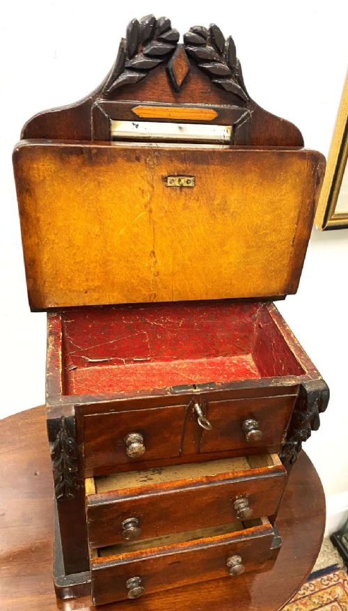 A Victorian miniature mahogany chiffonier featuring a small rectangular mirror, carved leaf cresting, inlaid diamond motifs, and small drawers with turned knobs. View III