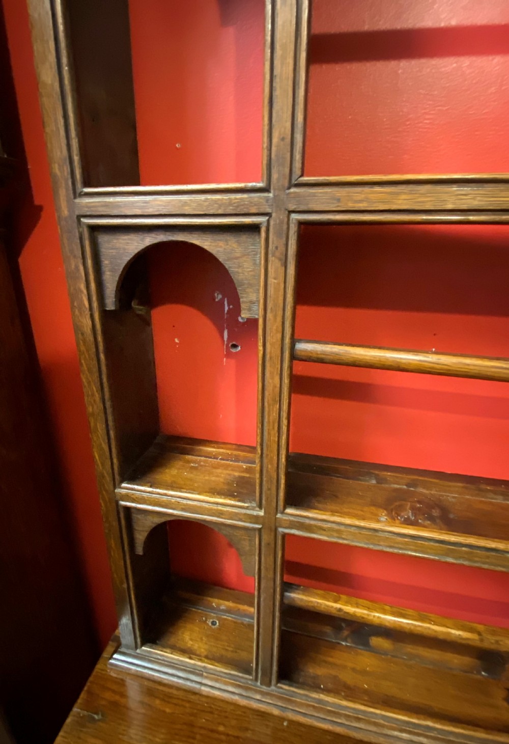 A George III oak dresser featuring an open upper plate rack with slender horizontal rails above three drawers and lower panelled cupboards with brass fittings. View X