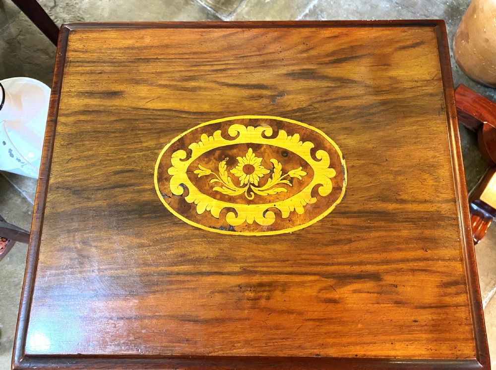 A Victorian walnut sewing table featuring a hinged lid decorated with an oval floral marquetry inlay set upon a carved tripod pedestal base. View IV