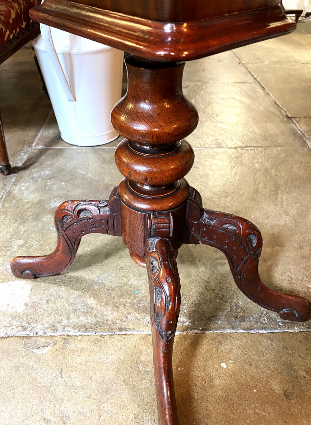 A Victorian walnut sewing table featuring a hinged lid decorated with an oval floral marquetry inlay set upon a carved tripod pedestal base. View V