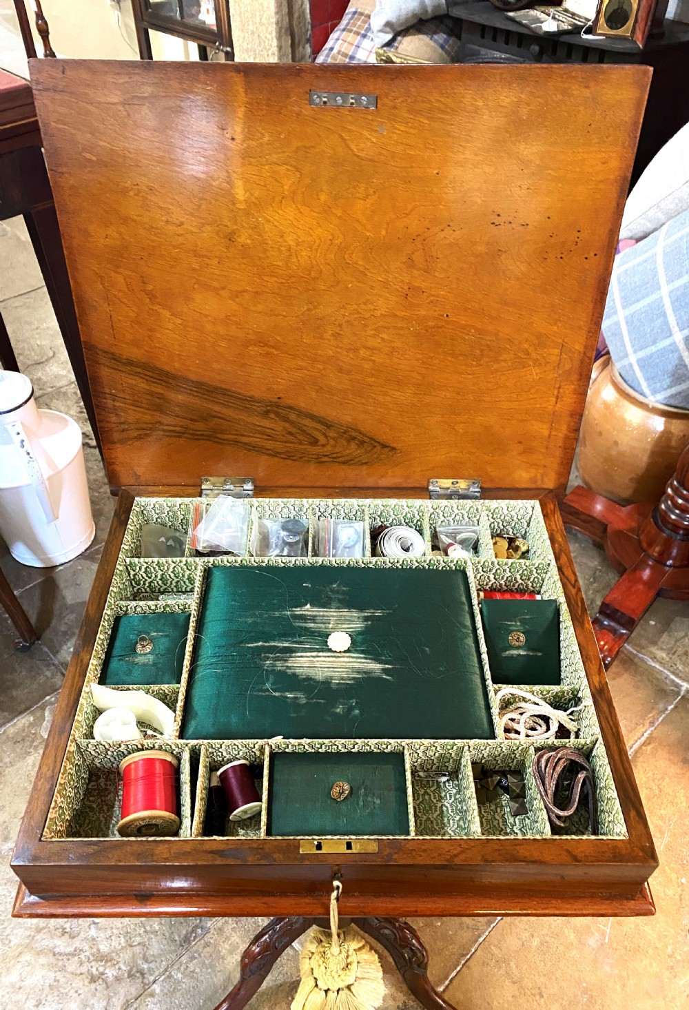 A Victorian walnut sewing table featuring a hinged lid decorated with an oval floral marquetry inlay set upon a carved tripod pedestal base. View VII