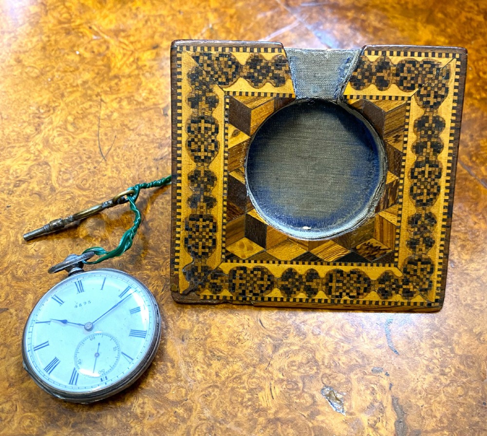 A square Victorian Tunbridge ware wooden pocket watch stand featuring geometric mosaic parquetry around a central pocket watch. View IV