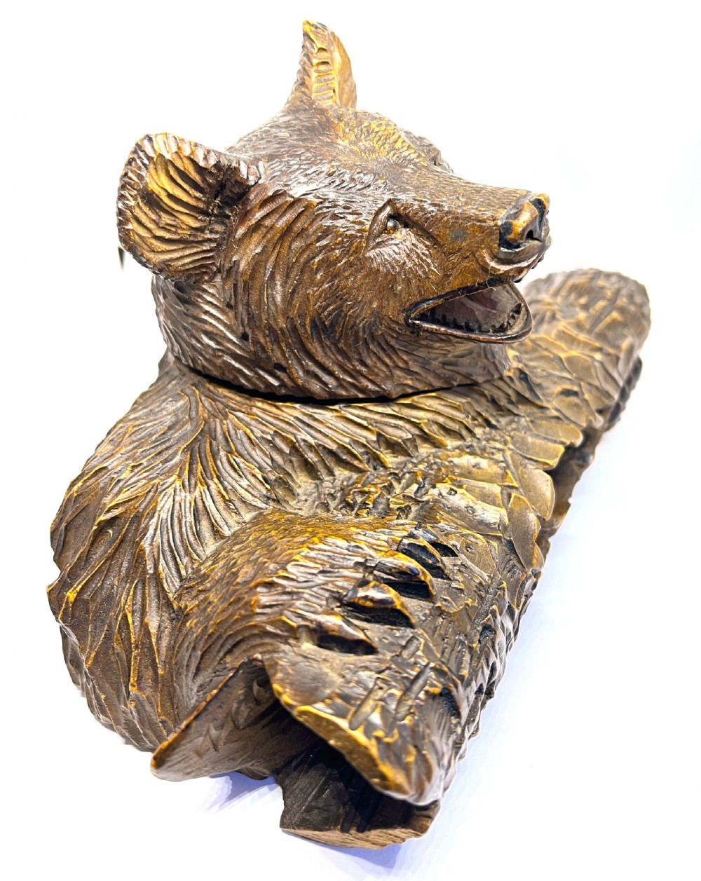 A hand-carved dark wood inkwell formed as a bear leaning over a hollow log. View III