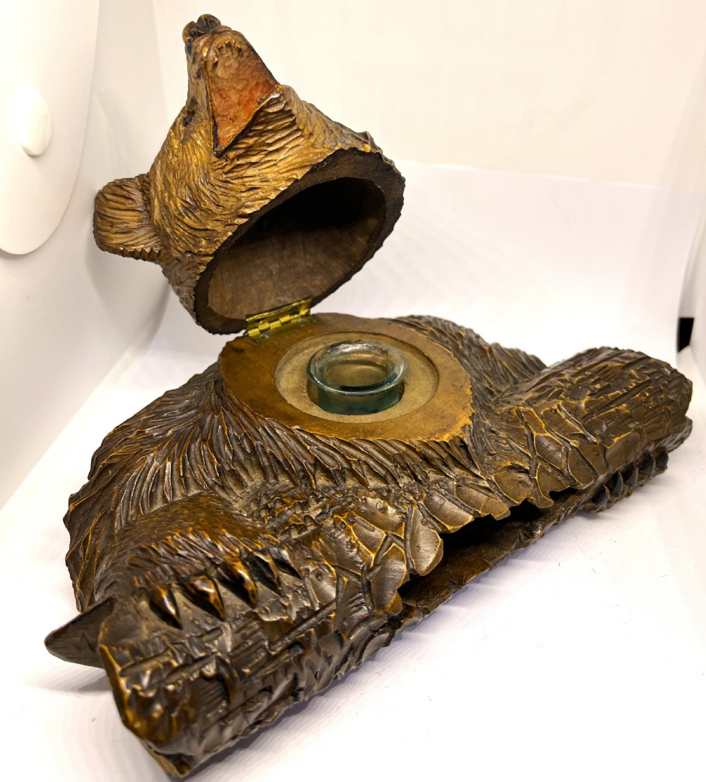 A hand-carved dark wood inkwell formed as a bear leaning over a hollow log. View IV