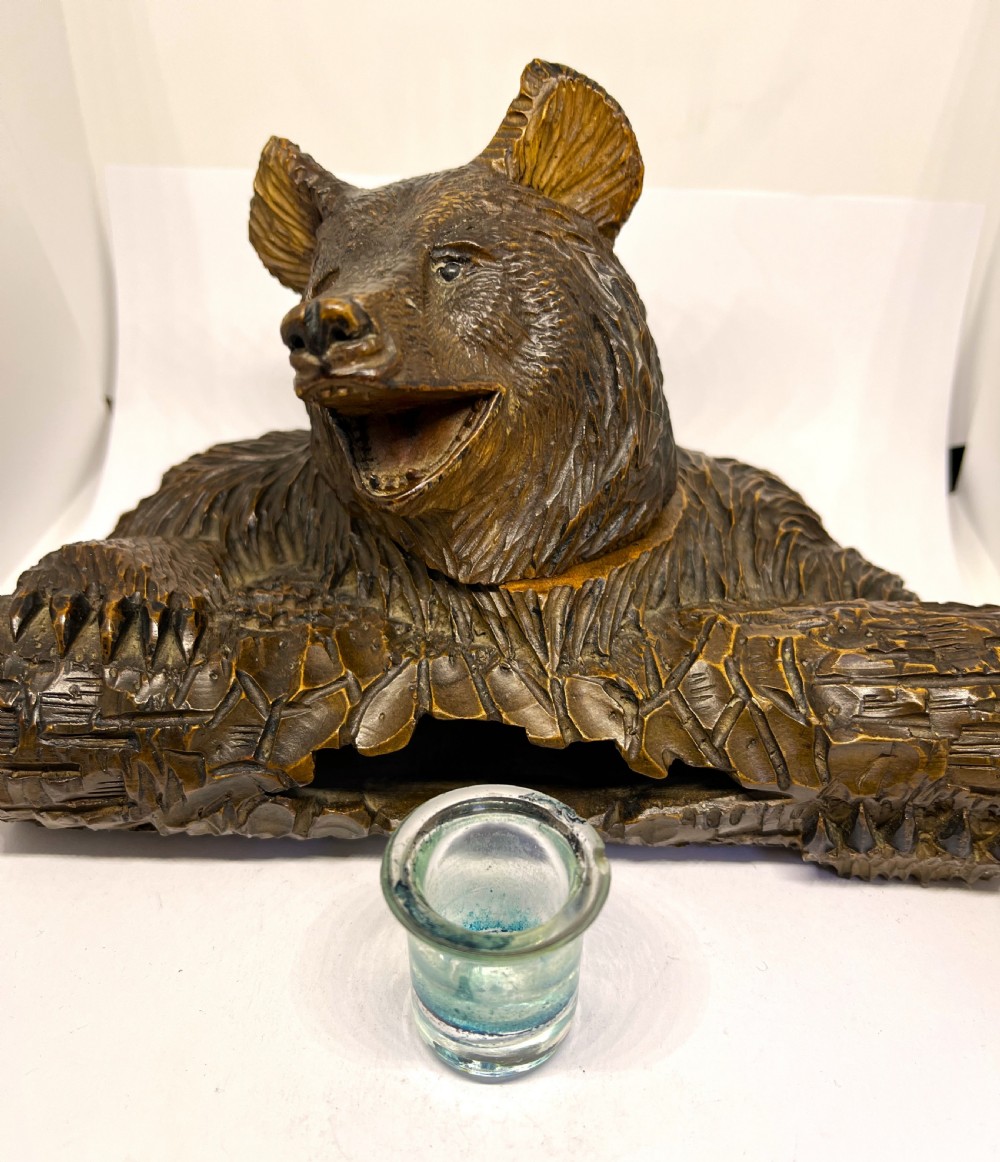 A hand-carved dark wood inkwell formed as a bear leaning over a hollow log. View V