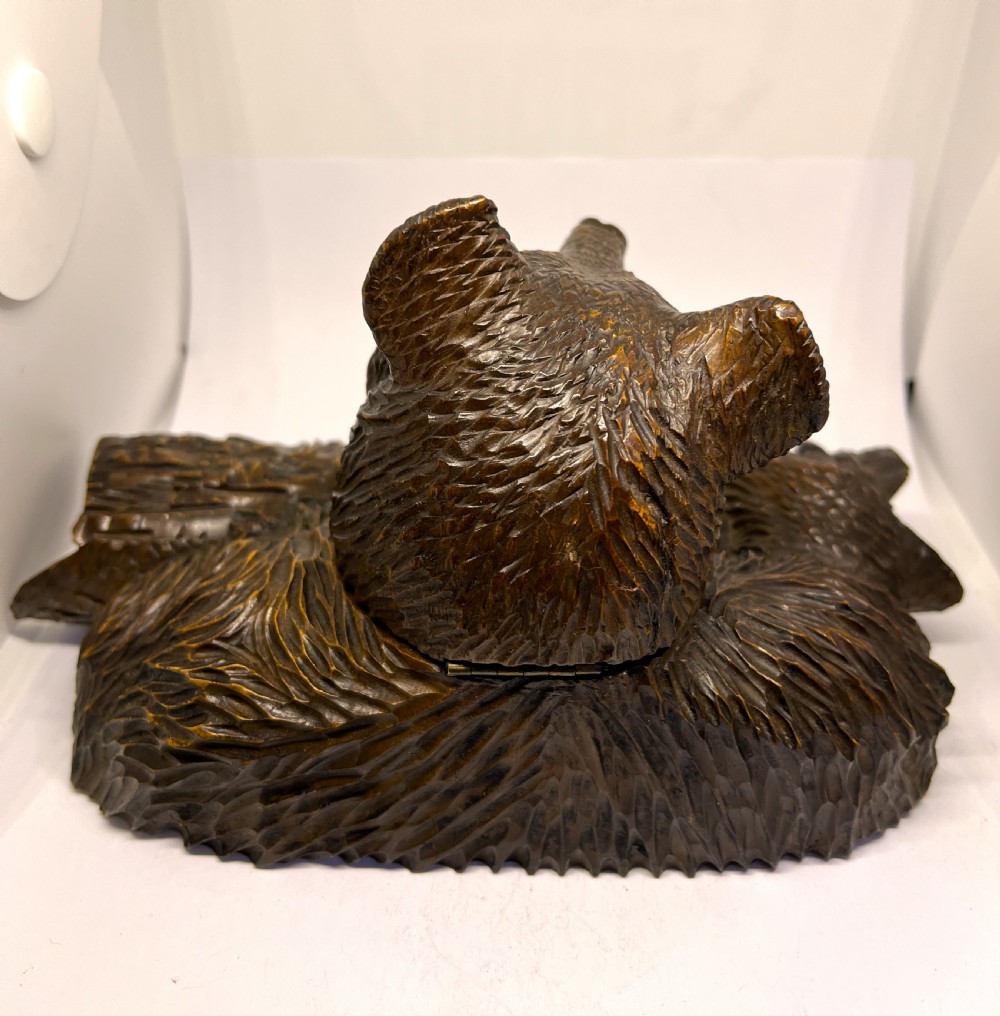 A hand-carved dark wood inkwell formed as a bear leaning over a hollow log. View VI