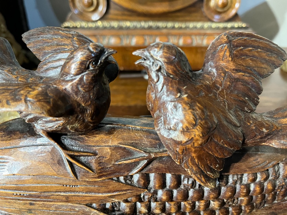 A dark hand-carved wooden double inkwell featuring two birds perched on a ear of corn with an integrated pen tray base. View II