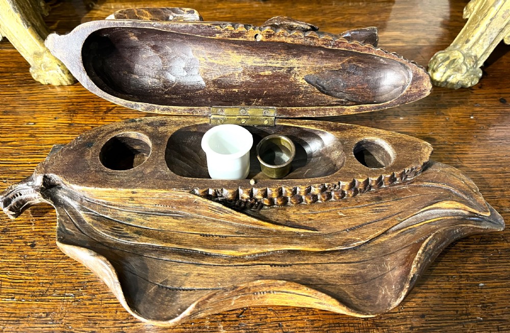 A dark hand-carved wooden double inkwell featuring two birds perched on a ear of corn with an integrated pen tray base. View IV