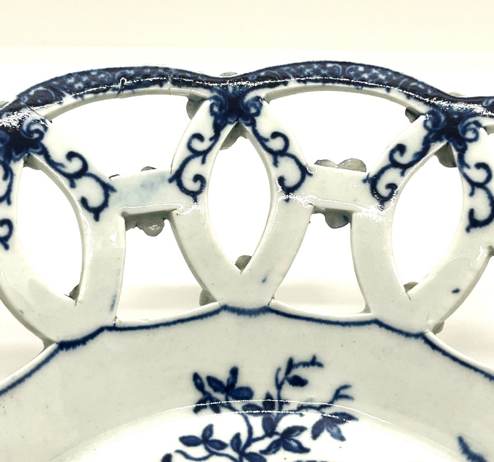 An 18th-century First Period Worcester circular soft-paste porcelain basket featuring a reticulated lattice rim and blue and white transfer-printed pinecone pattern. View III