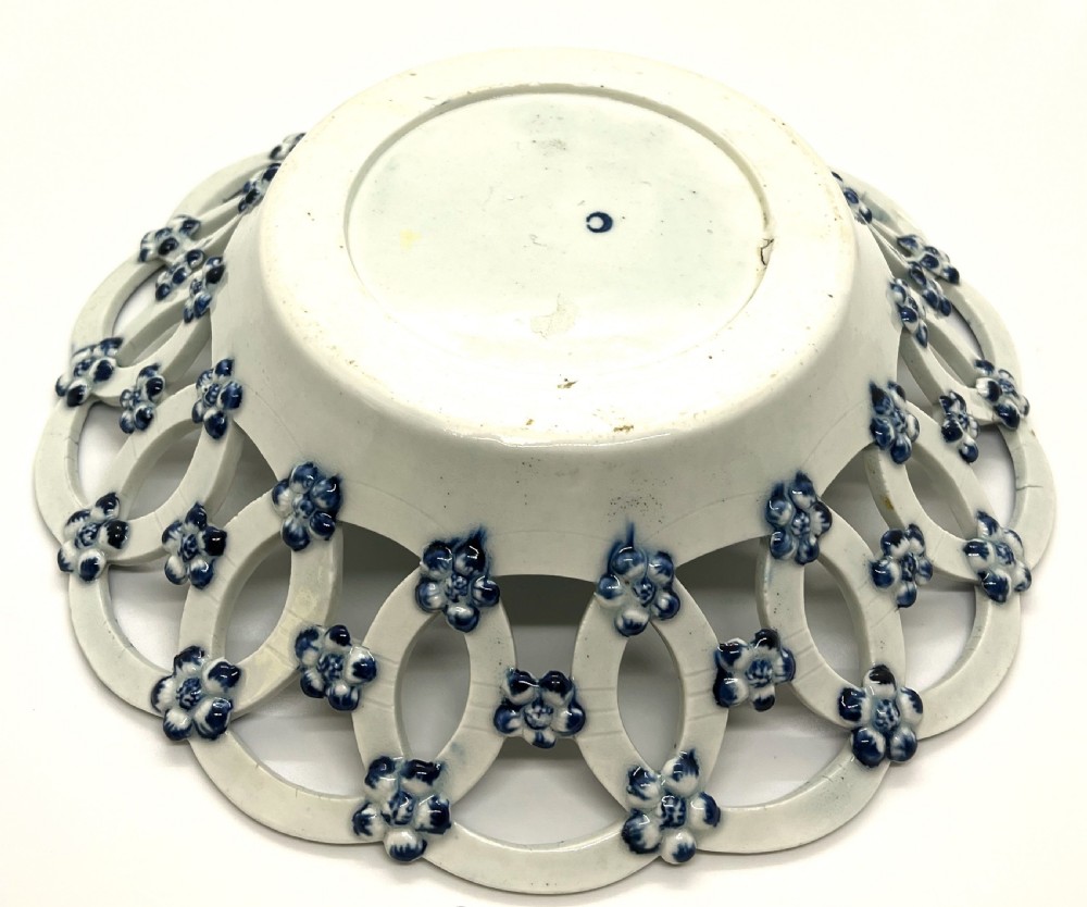 An 18th-century First Period Worcester circular soft-paste porcelain basket featuring a reticulated lattice rim and blue and white transfer-printed pinecone pattern. View IV