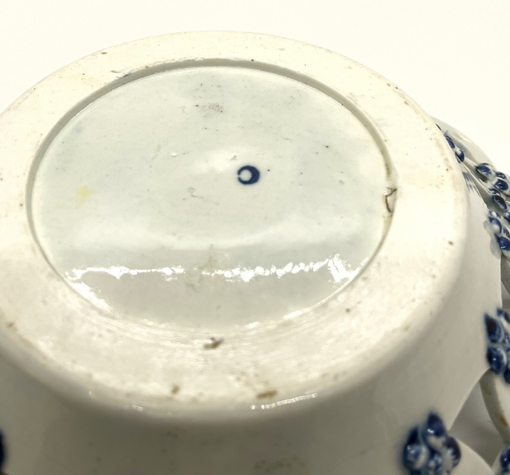 An 18th-century First Period Worcester circular soft-paste porcelain basket featuring a reticulated lattice rim and blue and white transfer-printed pinecone pattern. View V