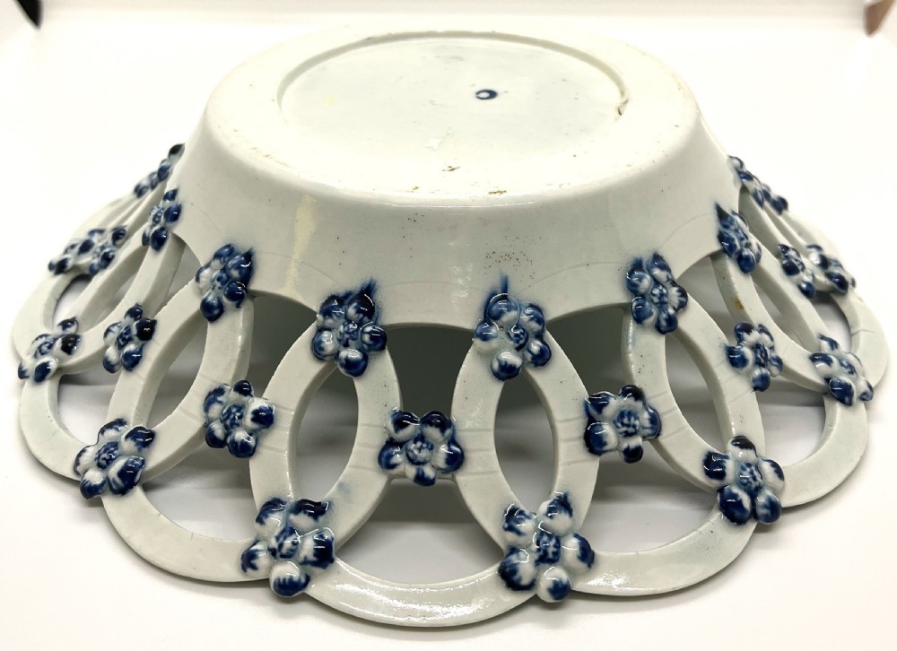 An 18th-century First Period Worcester circular soft-paste porcelain basket featuring a reticulated lattice rim and blue and white transfer-printed pinecone pattern. View VII