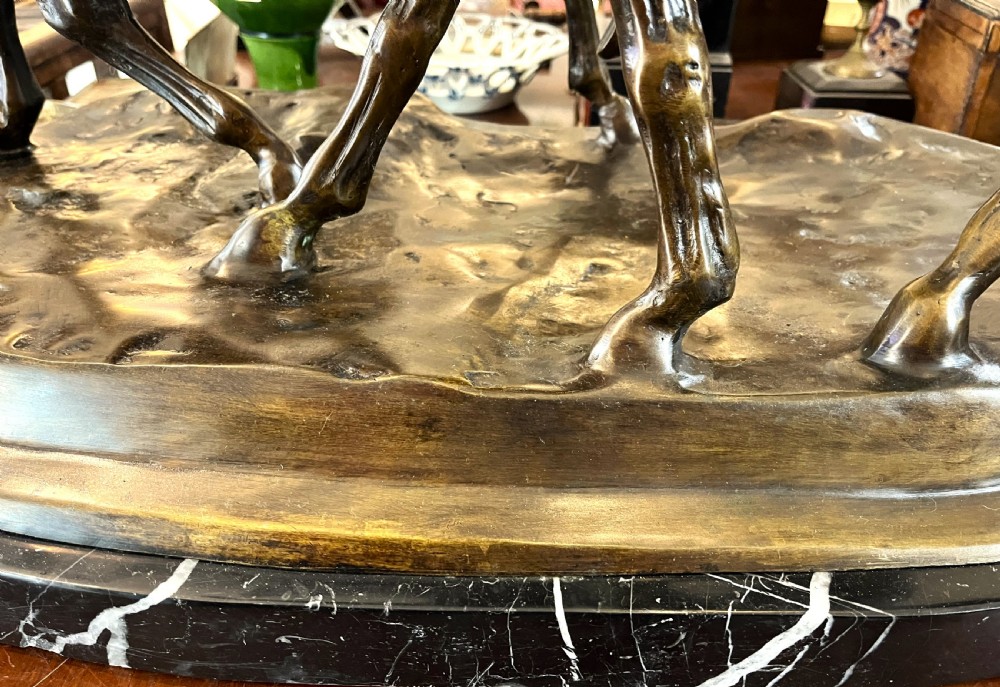 A bronze sculpture depicting two horses standing together on a naturalistic ground base mounted on an oval dark marble plinth. View IX