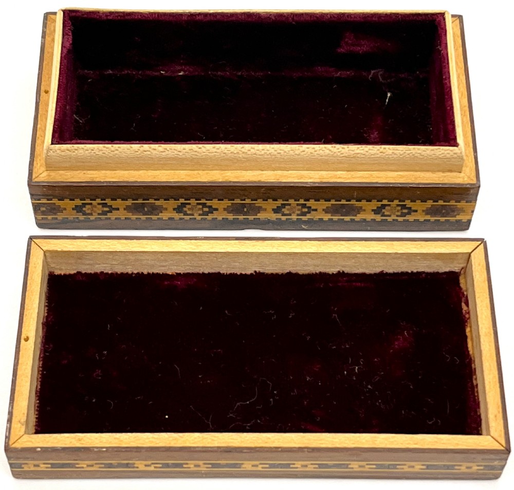 A rectangular dark wood box featuring an intricate tessellated mosaic floral design on the lid framed by geometric inlaid borders. View II